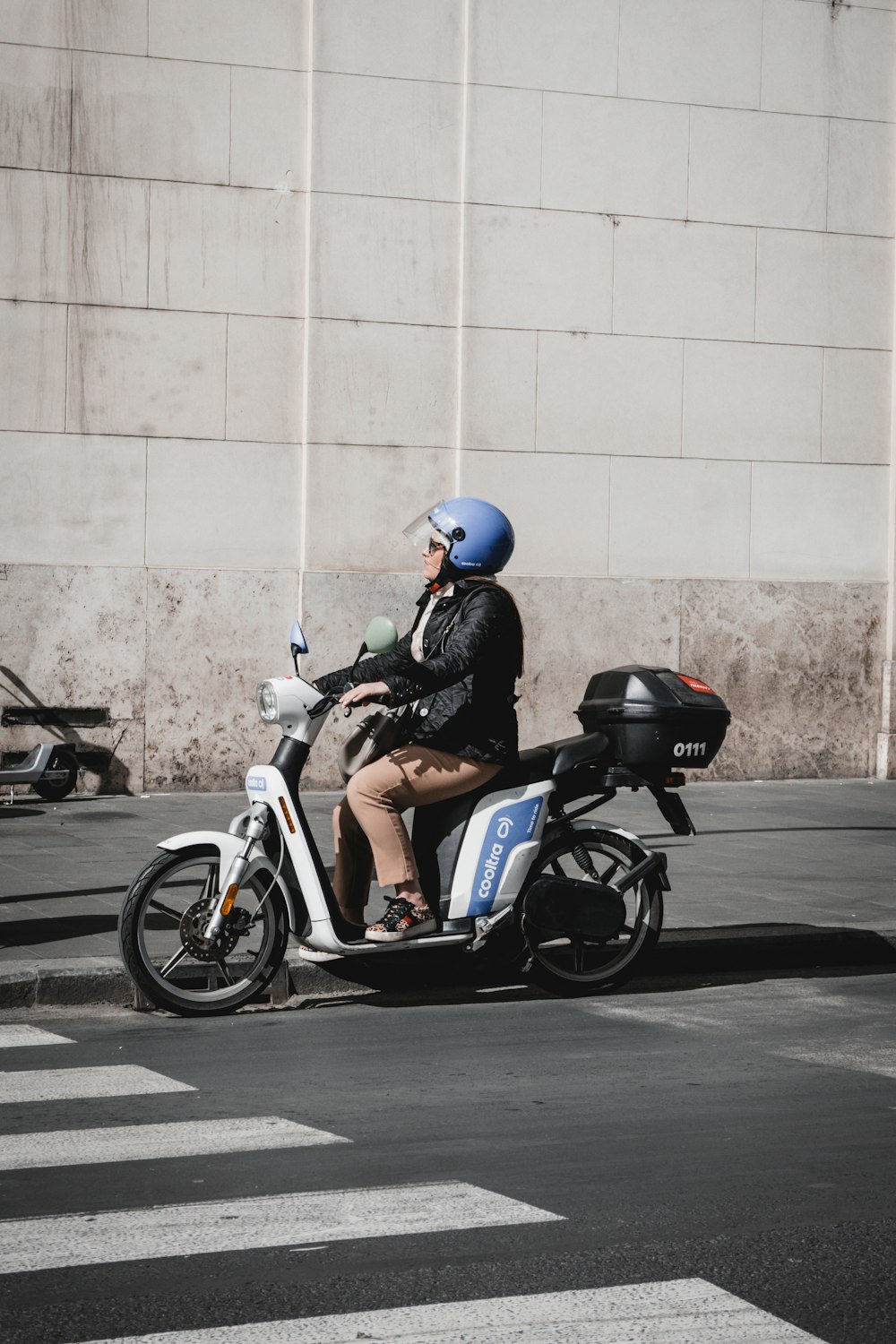 a person riding a scooter on a city street