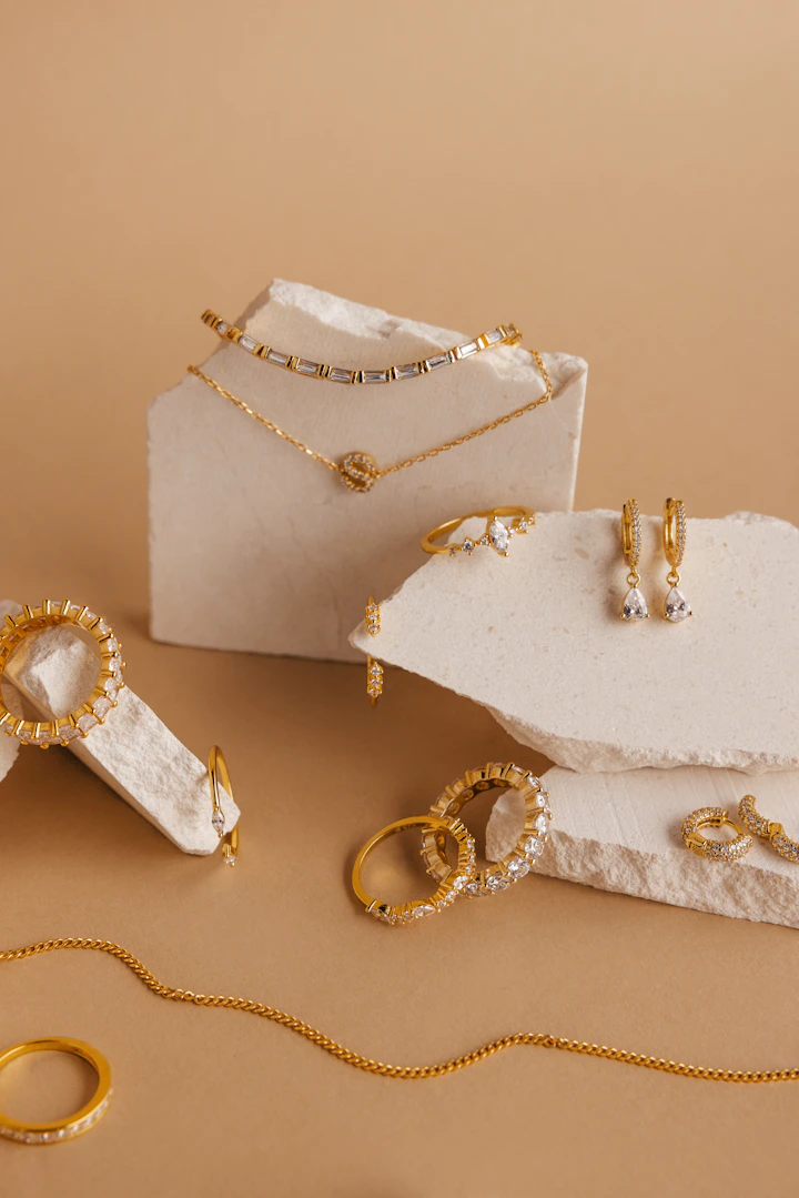 Coordinated gold jewellery set on a warm neutral display
