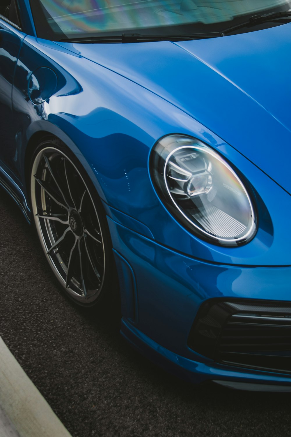 a blue sports car parked on the side of the road