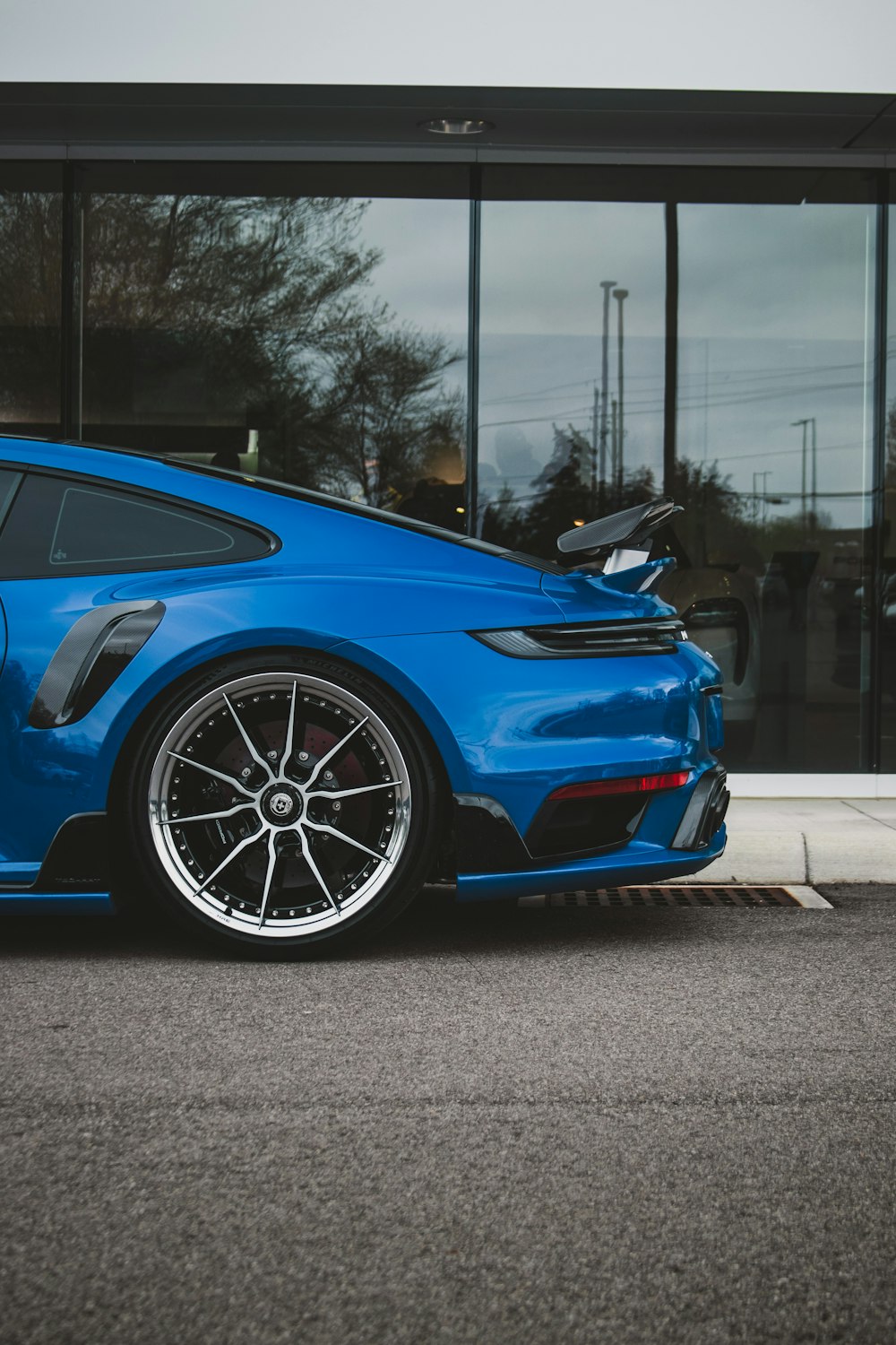 a blue sports car parked in front of a building