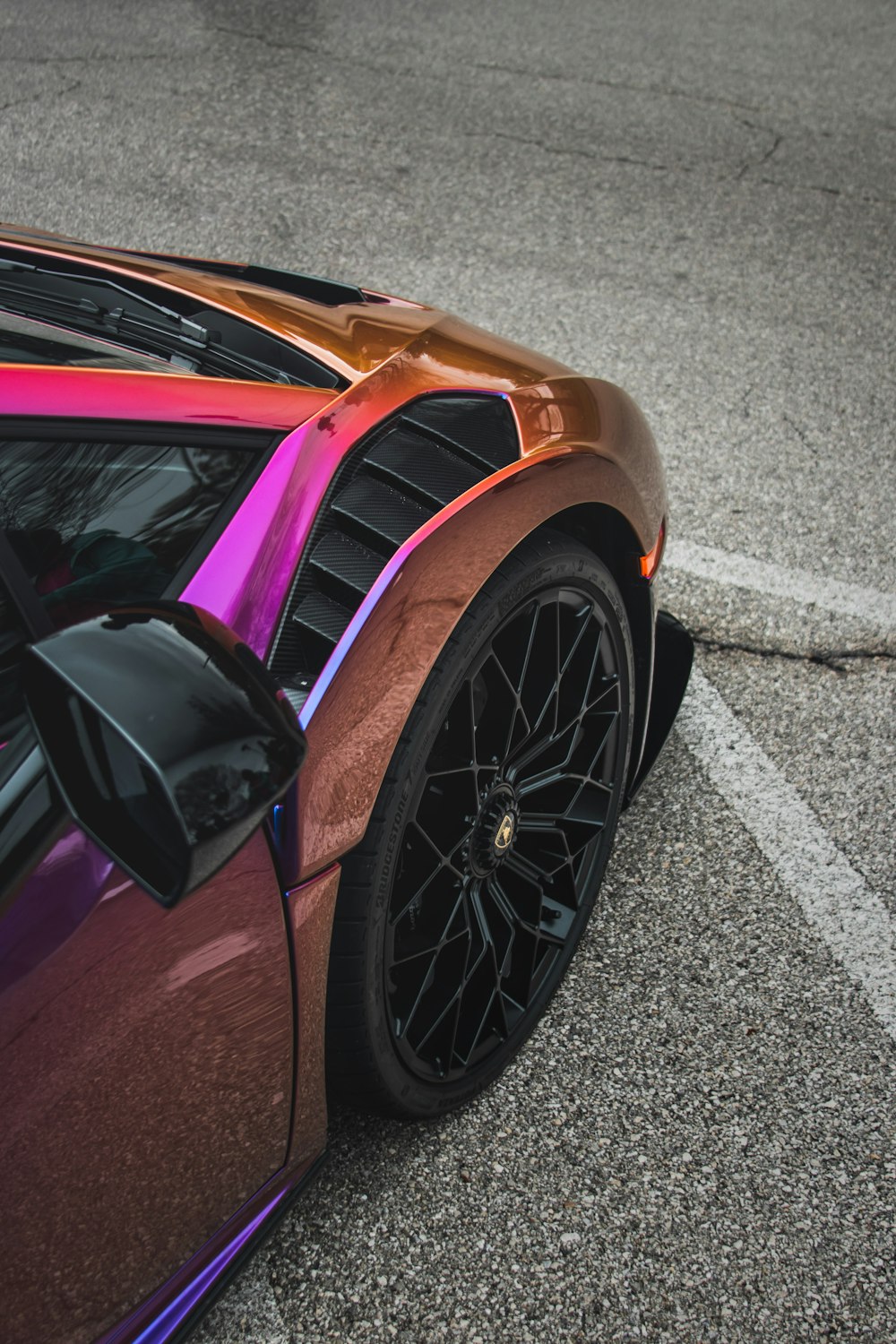 a purple and orange sports car parked in a parking lot