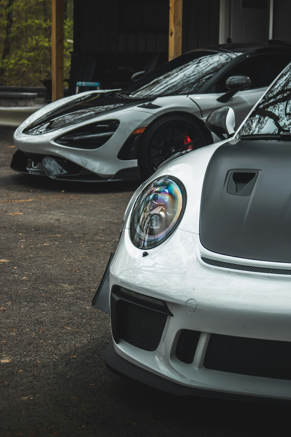 two white sports cars parked next to each other