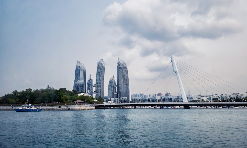 a bridge over a body of water with a city in the background