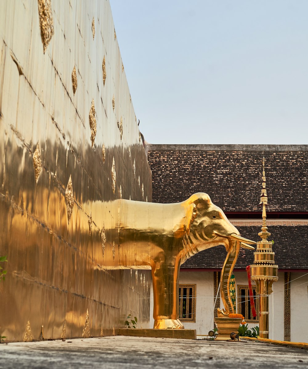 Una gran estatua de elefante dorado frente a un edificio