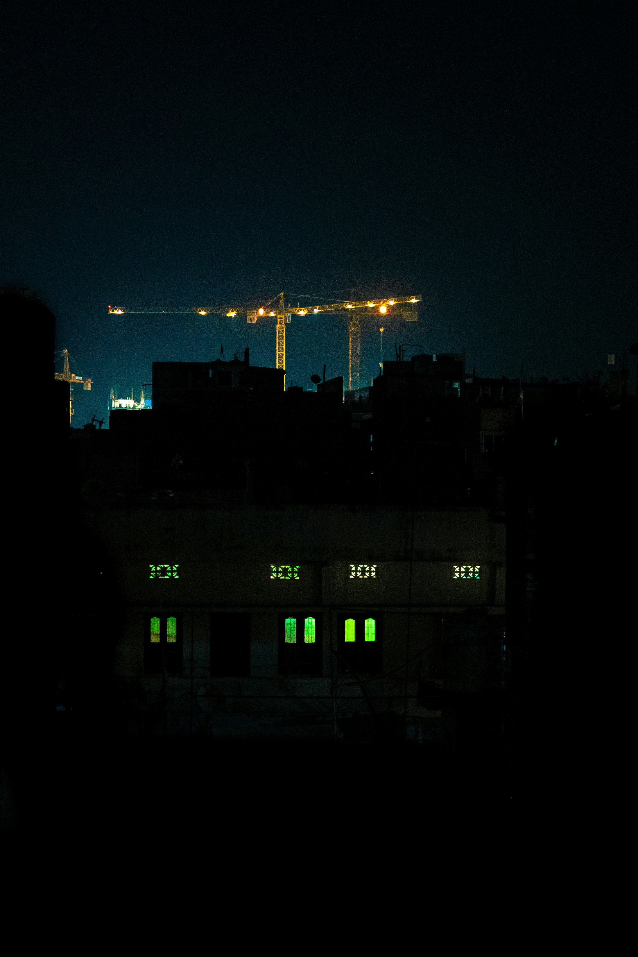 a view of a city at night with a crane in the background