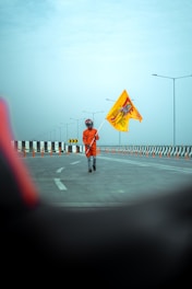 Close-up of a traffic flagger holding a stop/slow paddle under bright daylight.
