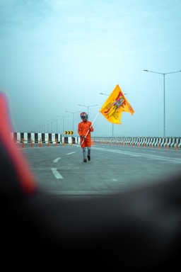 A friendly traffic flagger in safety gear guiding vehicles on a construction site.