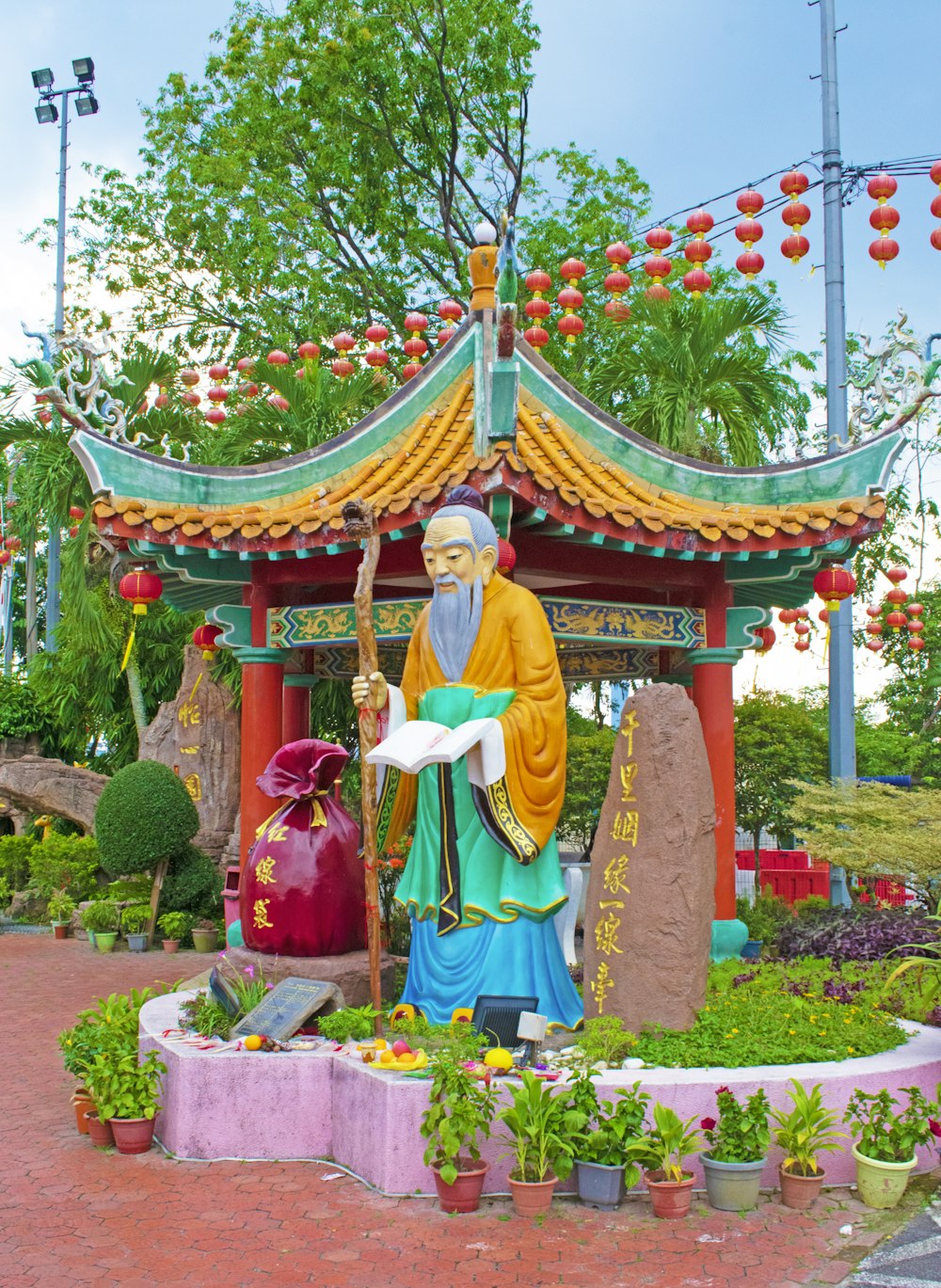 a statue of a man holding a staff in a garden