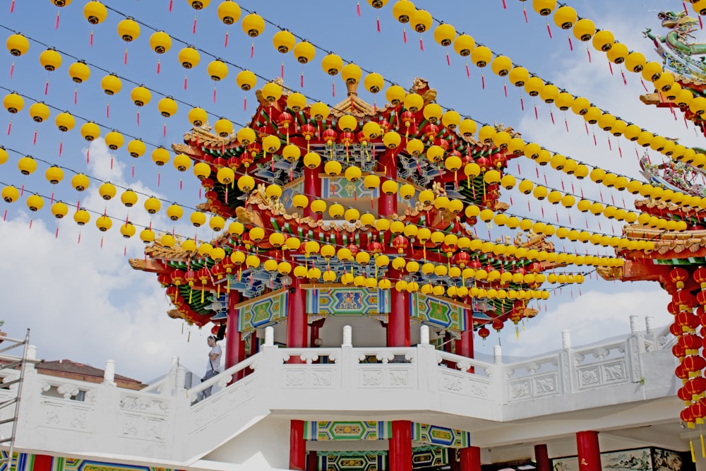 a building with yellow lanterns hanging from it's roof