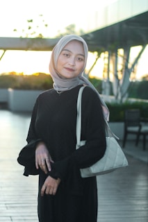 a woman wearing a hijab and carrying a purse