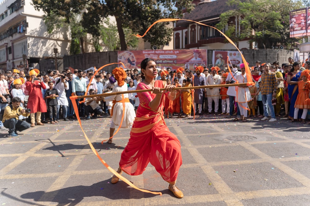 a woman in a red outfit is holding a bow and arrow