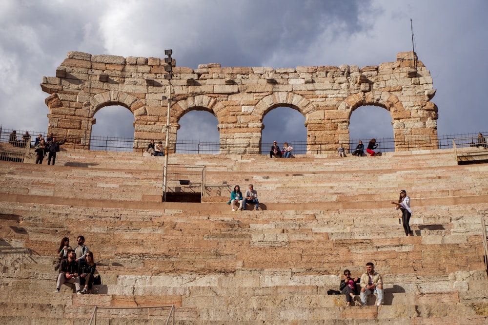 a group of people sitting on top of a stone stage