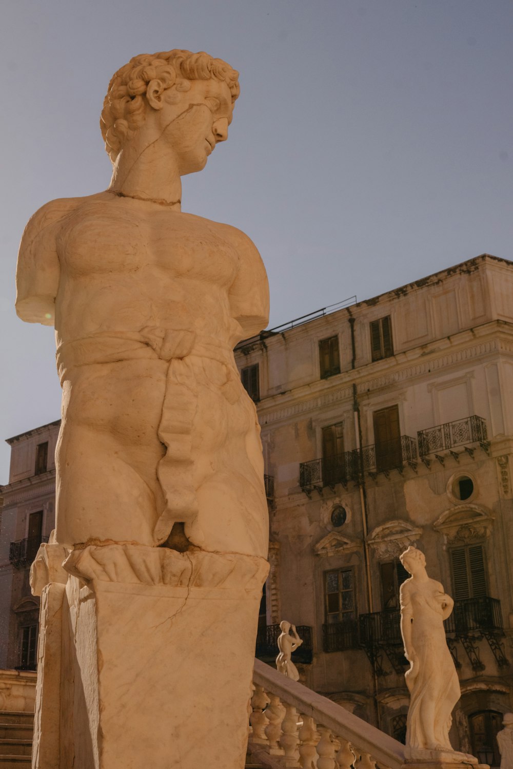 uma estátua de um homem em pé na frente de um edifício