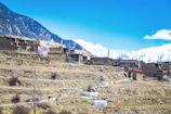 Traditional Himalayan village with terraced fields and community members working together.