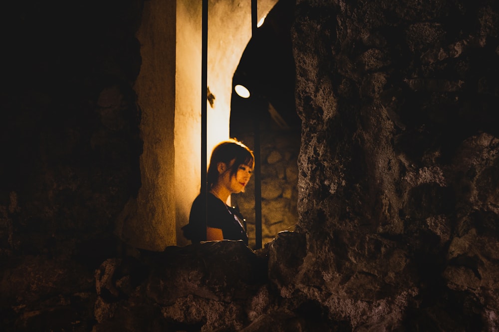 a person sitting in a cave looking at something