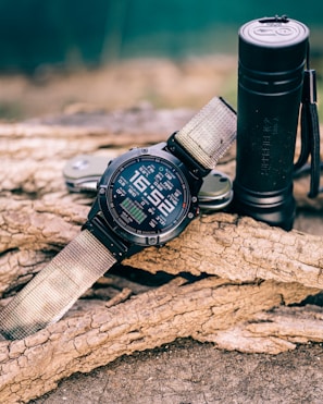 Close-up of a rugged multi-tool resting on a weathered backpack in a forest setting.