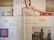 Several newspapers and magazines are arranged on a wooden surface. One magazine features a portrait of a woman with wet hair in a white top. Below are pages from a German newspaper with articles and images, including one of a man in a suit. The Economist magazine is partially visible on the right.