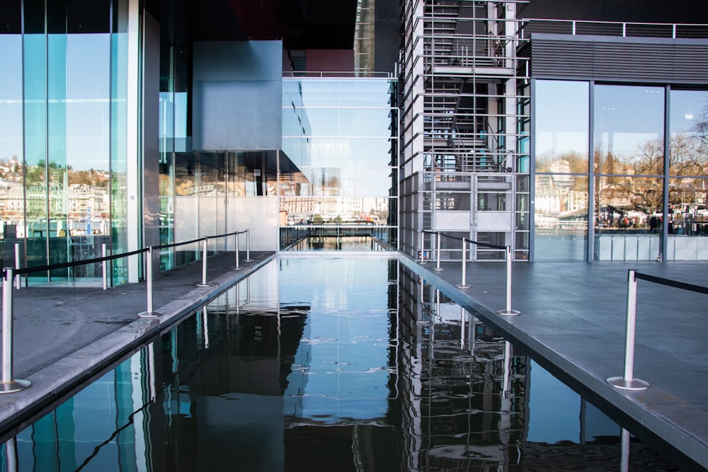 an empty pool in front of a glass building