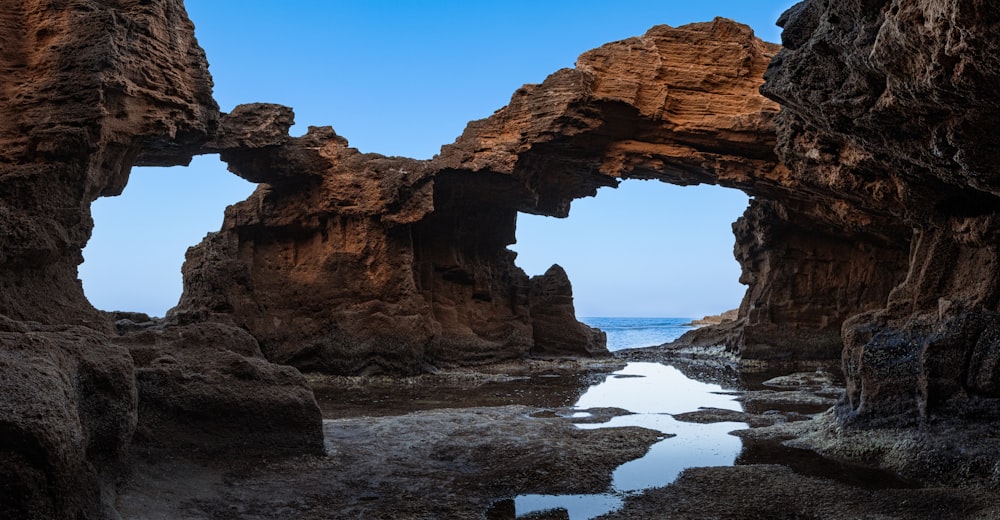 a rock formation with a body of water in front of it