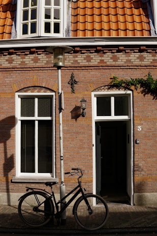 A delivery bicycle parked in front of a residential house.