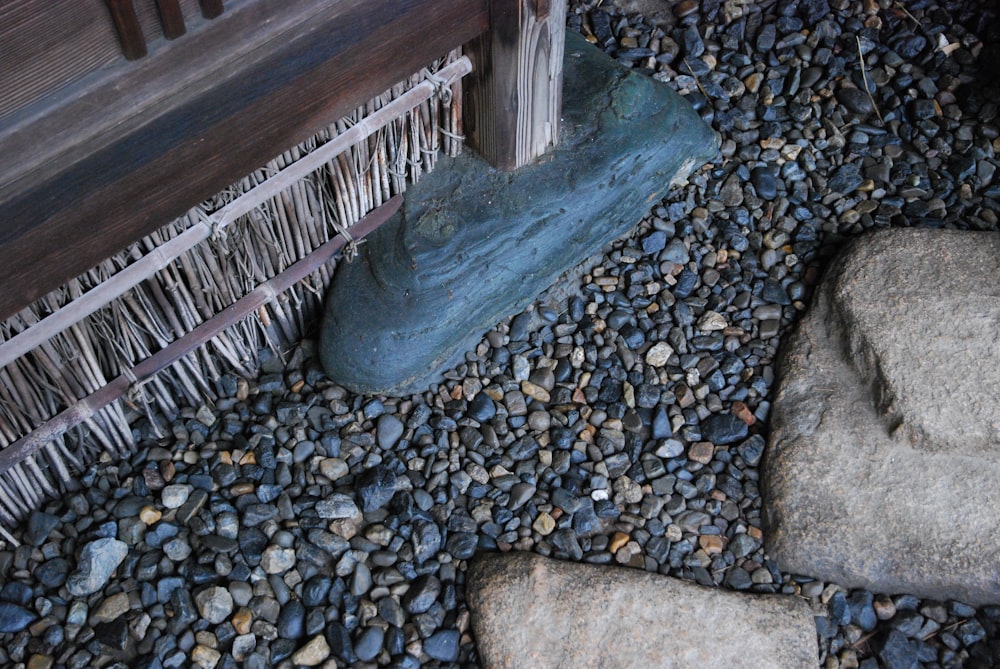 a close up of rocks and a bench on a gravel ground