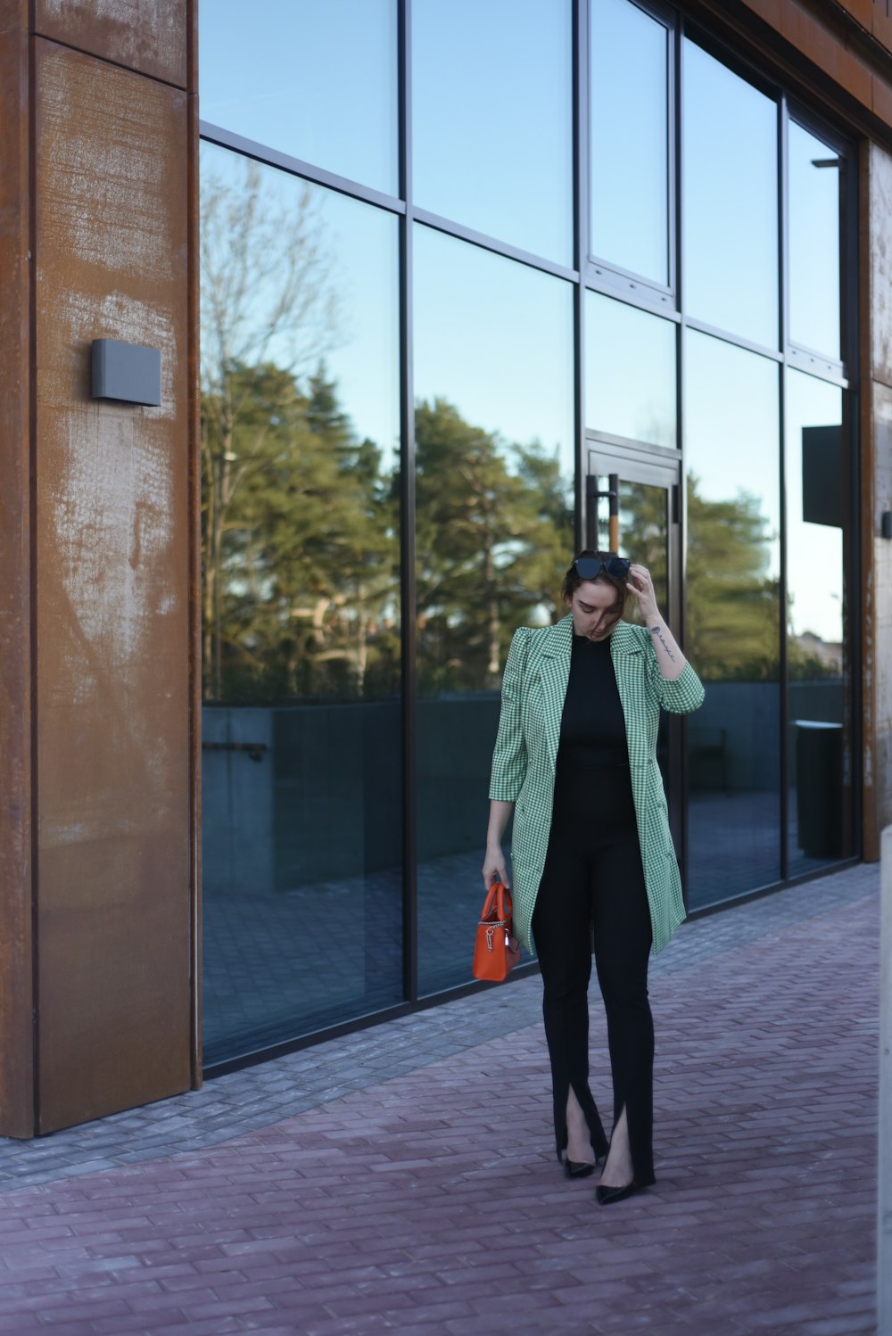 a woman walking down a sidewalk next to a building