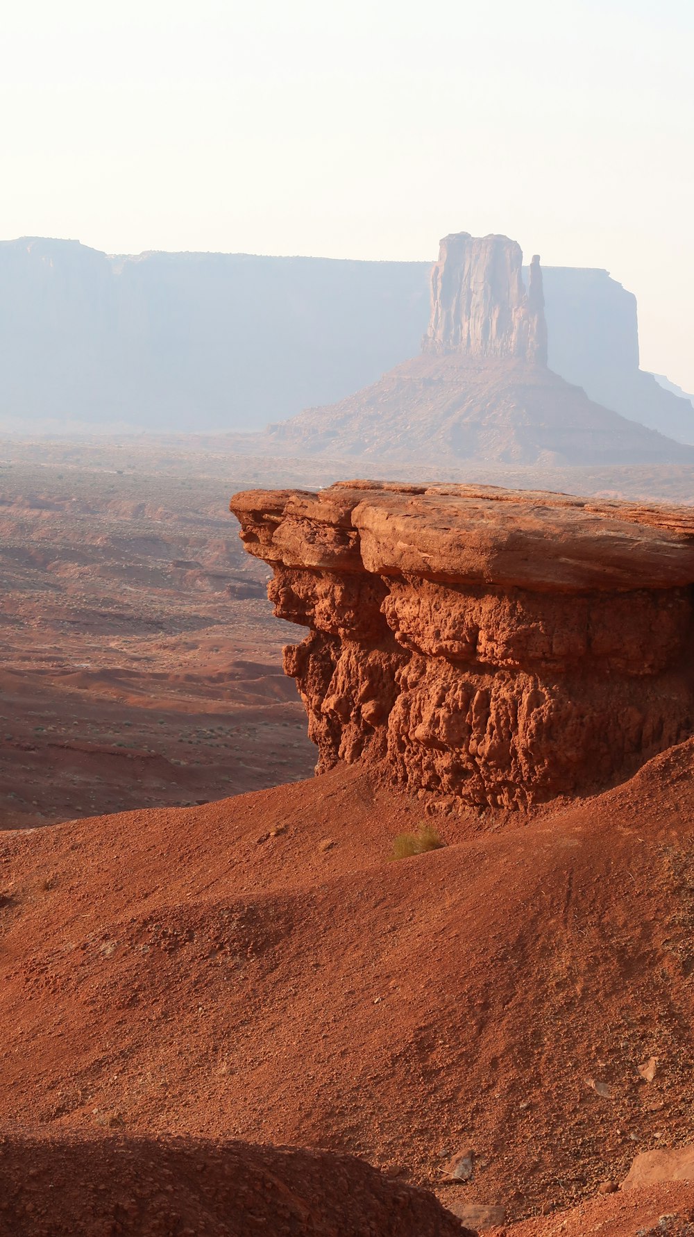 a rock formation in the desert with a mountain in the background