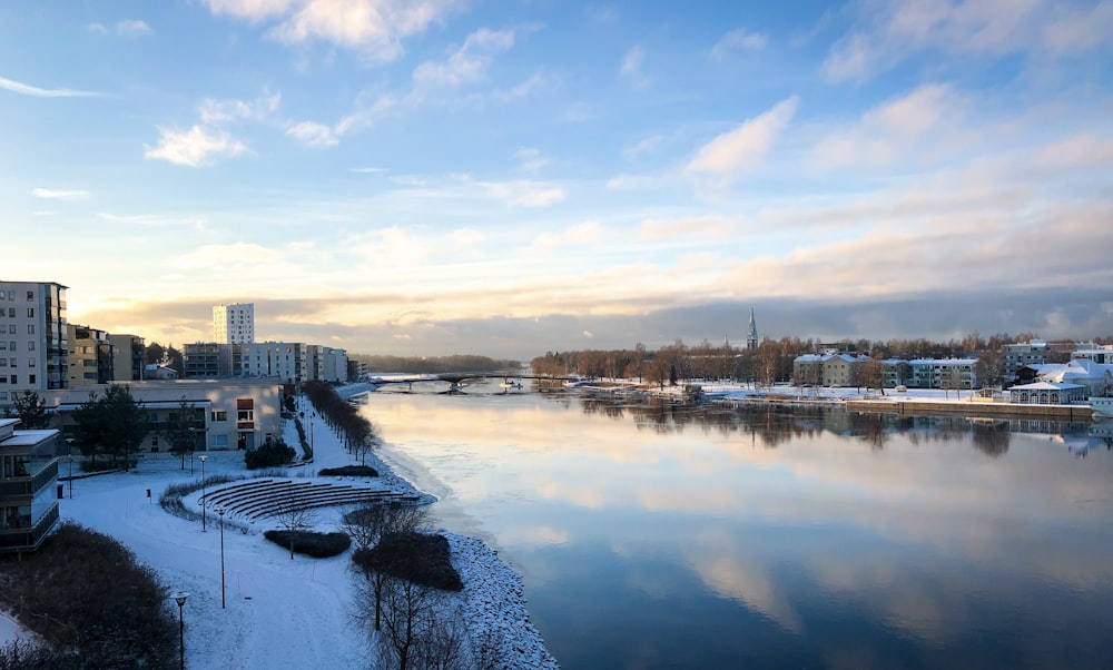 a body of water surrounded by snow covered buildings