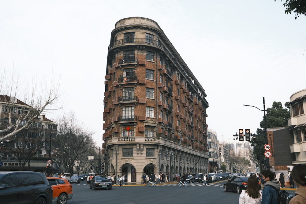 a very tall building on the corner of a busy street