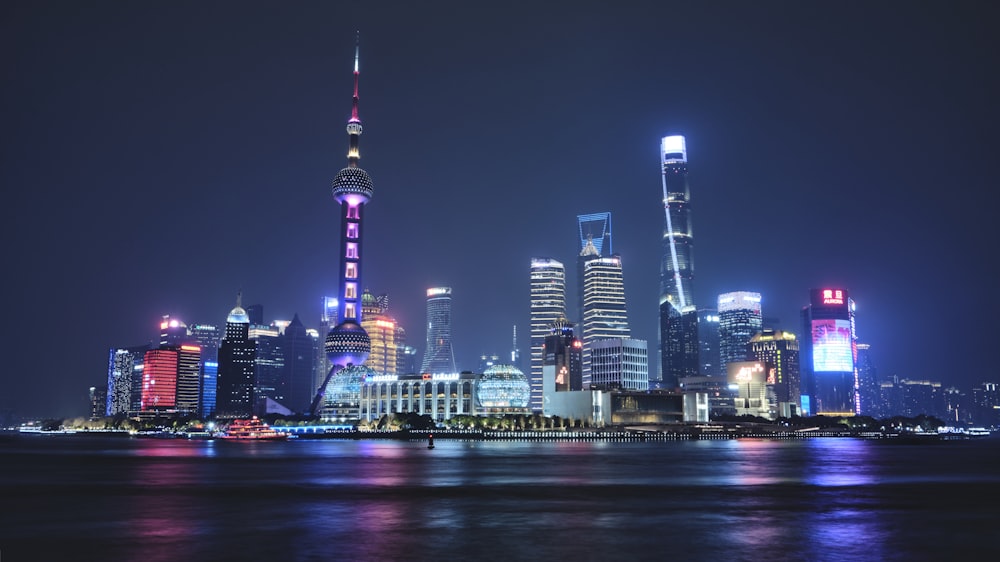 a city skyline at night with lights reflecting off the water