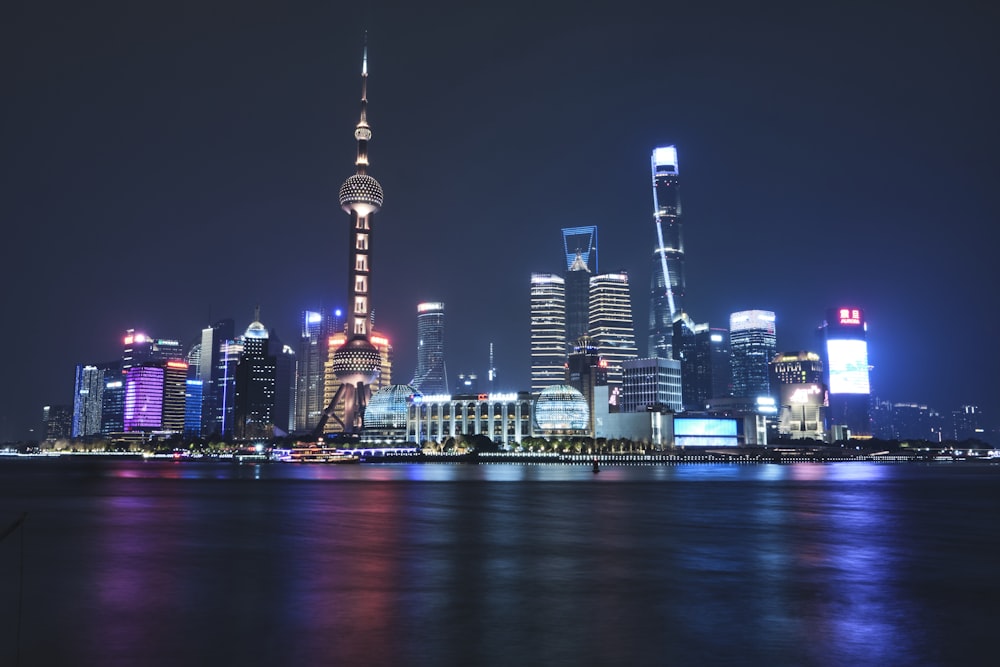 a city skyline at night with lights reflecting off the water