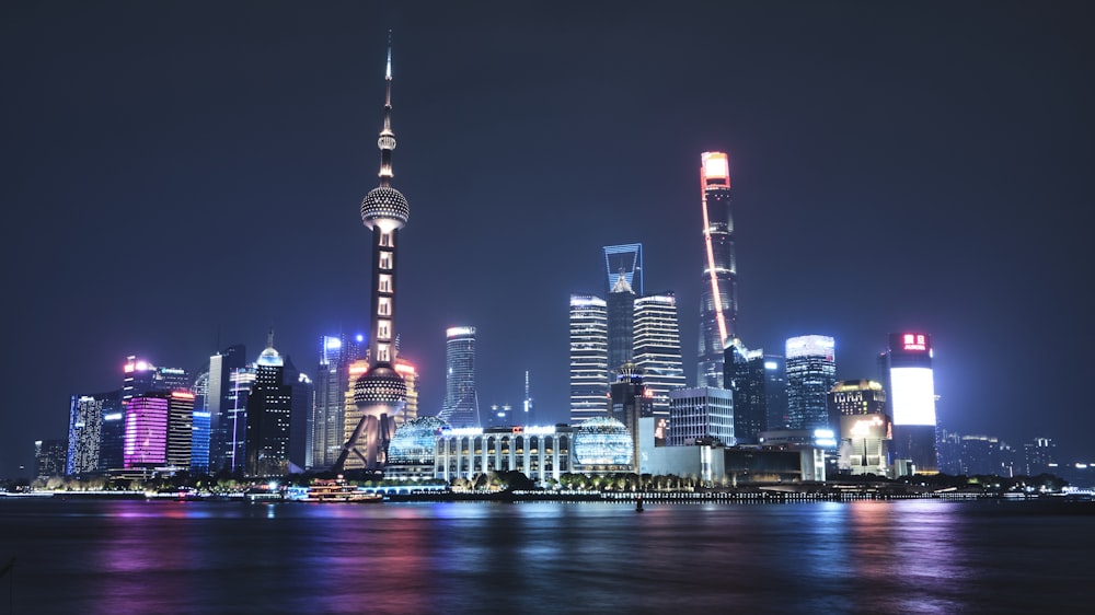 a city skyline at night with lights reflecting off the water