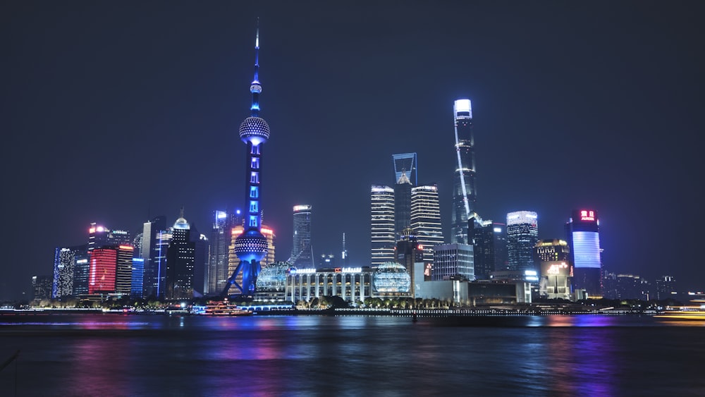 a city skyline at night with lights reflecting off the water