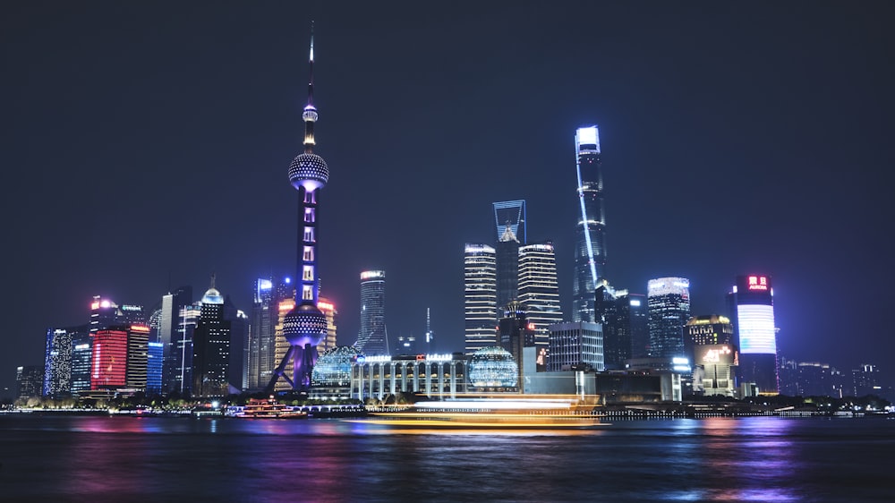 a city skyline at night with lights reflecting off the water