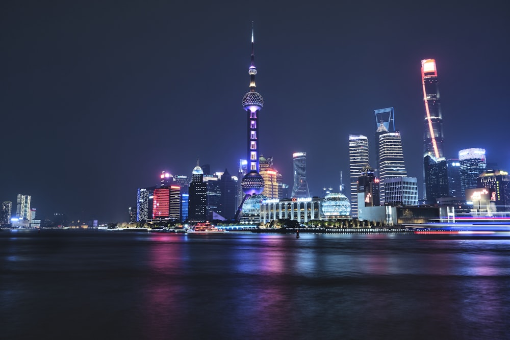 a city skyline at night with lights reflecting off the water