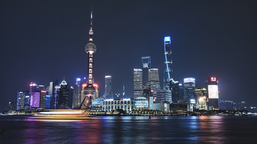 a city skyline at night with lights reflecting off the water