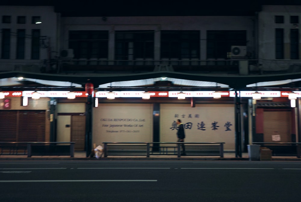 a man standing on a street corner at night
