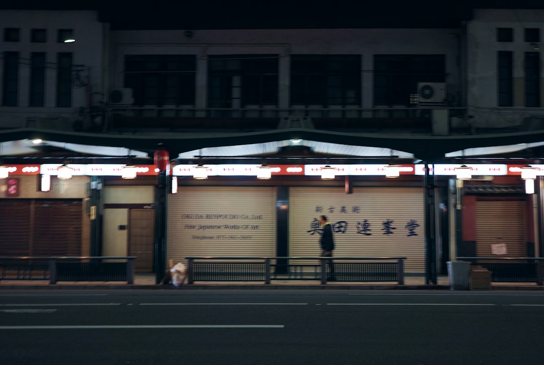 a man standing on a street corner at night,