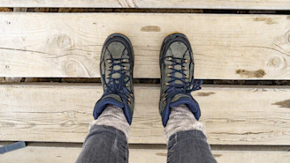 Sturdy hiking boots placed on a wooden deck with mountain views.