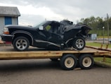 A damaged vehicle being loaded onto a tow truck.