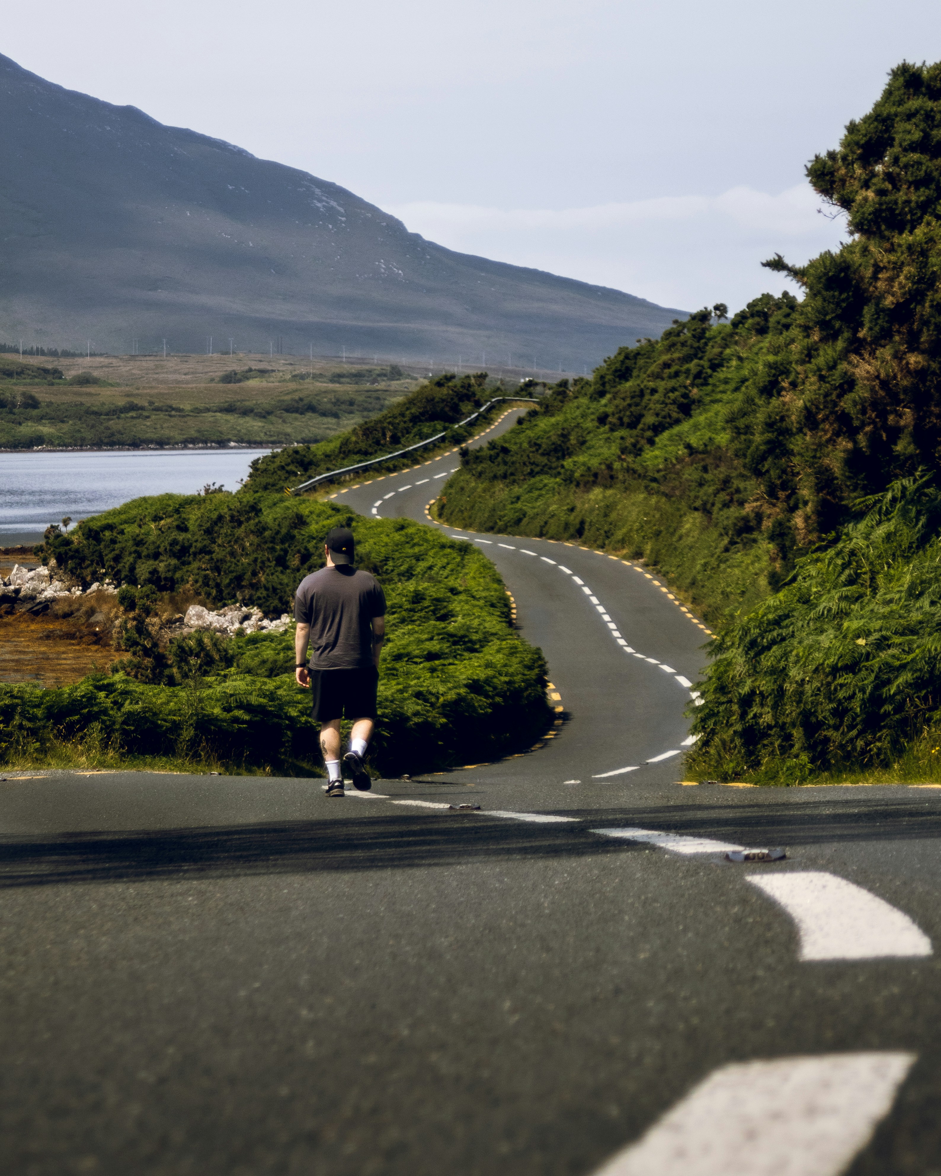 a man running down a road with a mountain in the background