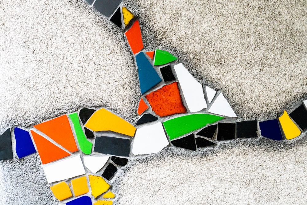 a multicolored bird made out of broken glass