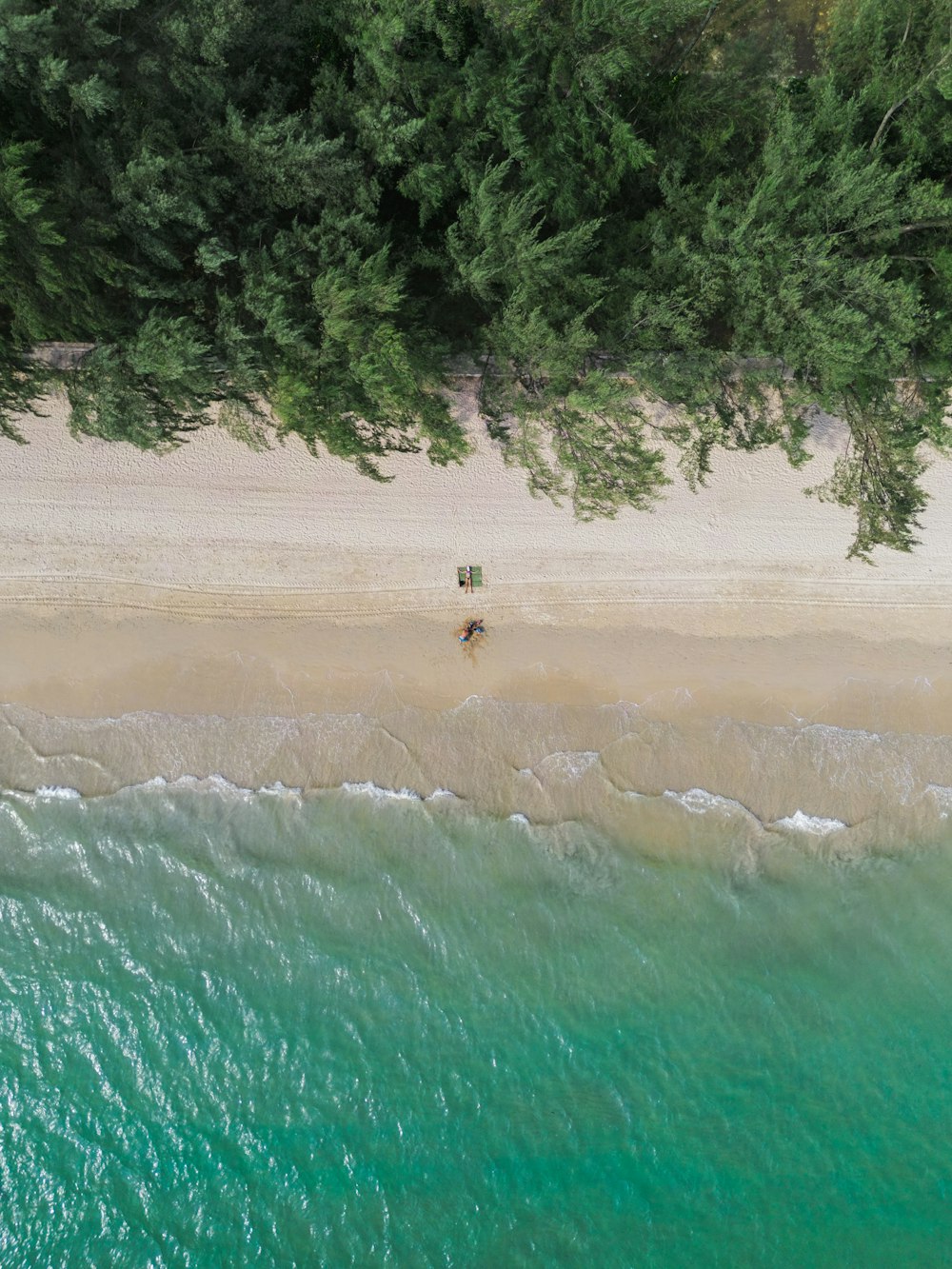 an aerial view of a beach with a couple of umbrellas