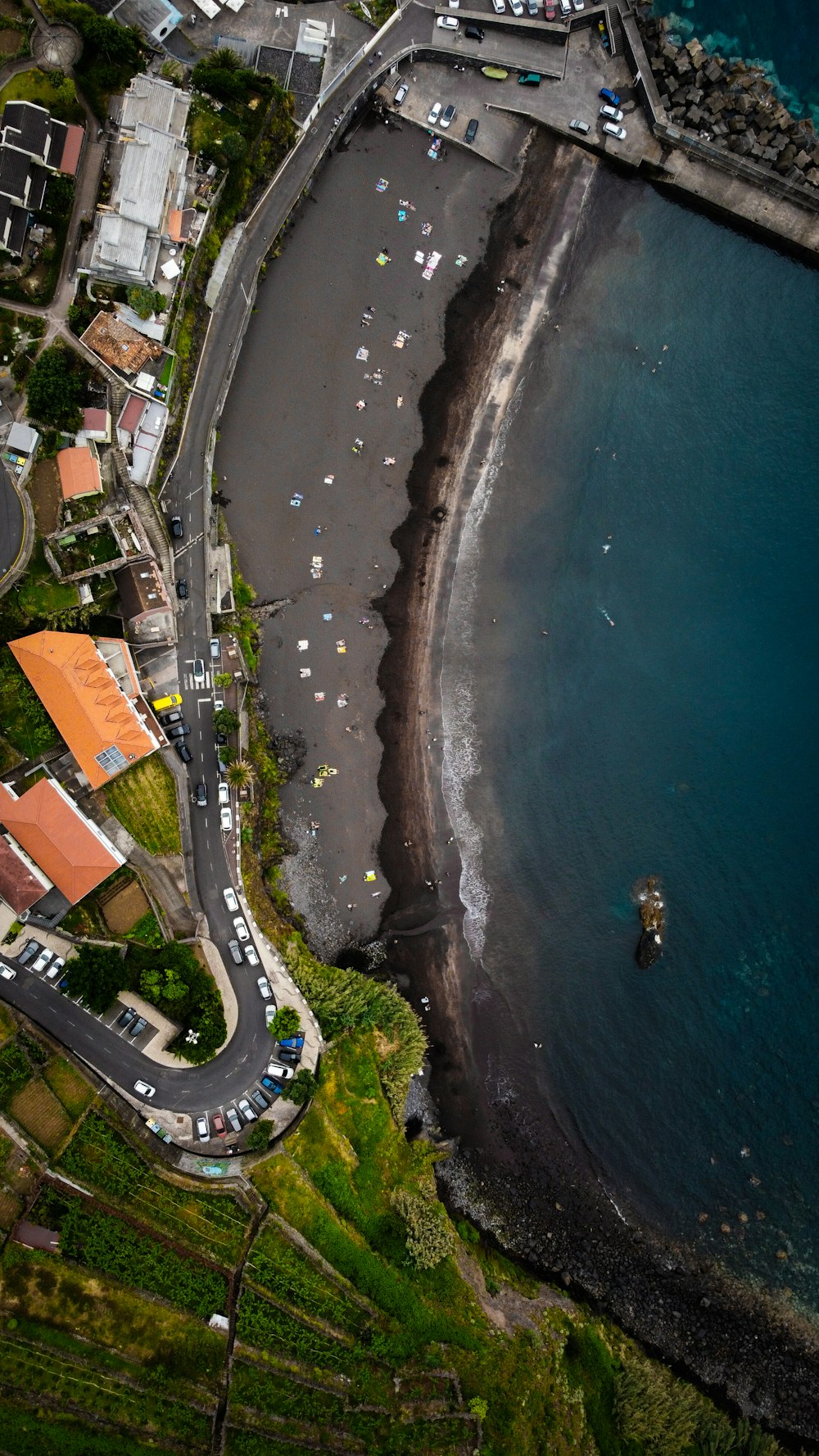 an aerial view of a road next to a body of water