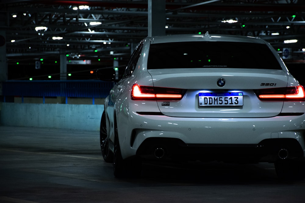 a white bmw car parked in a parking garage