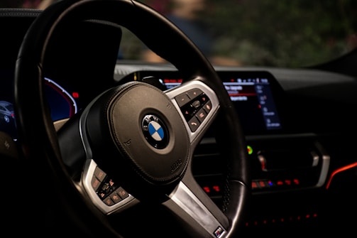 Close-up of a sleek car dashboard featuring custom LED lighting and a stylish steering cover.
