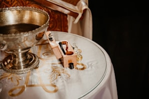 An ornate chalice filled with a deep red drink, resting on a carved wooden altar.