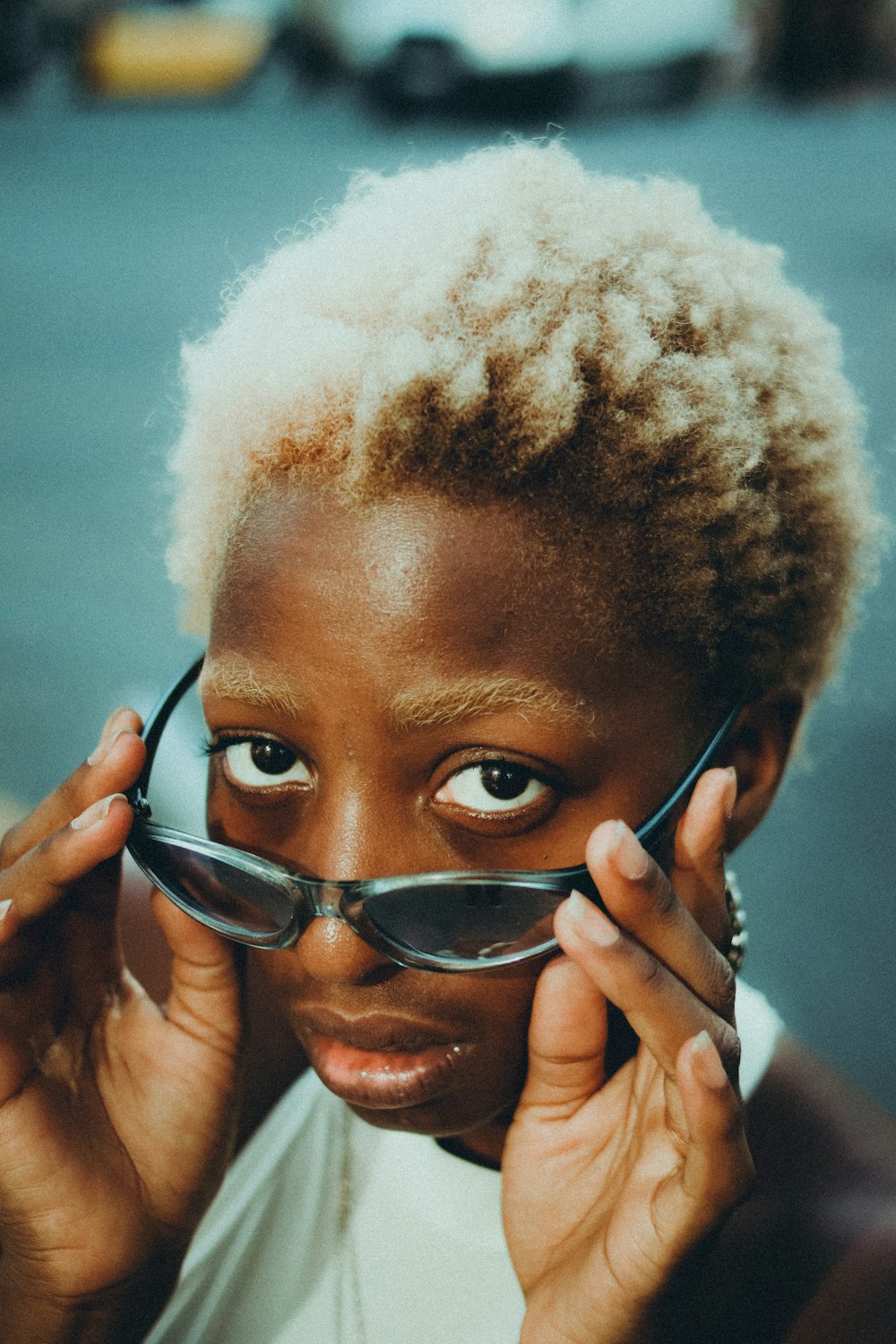 a woman holding up a pair of glasses to her face