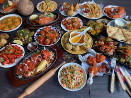 A beautifully arranged catering spread featuring vibrant Indian and Pakistani dishes.