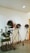 Three vintage film spotlights on tripod stands are arranged in a row against a plain white wall. To the left, there is an old-fashioned film editing machine.